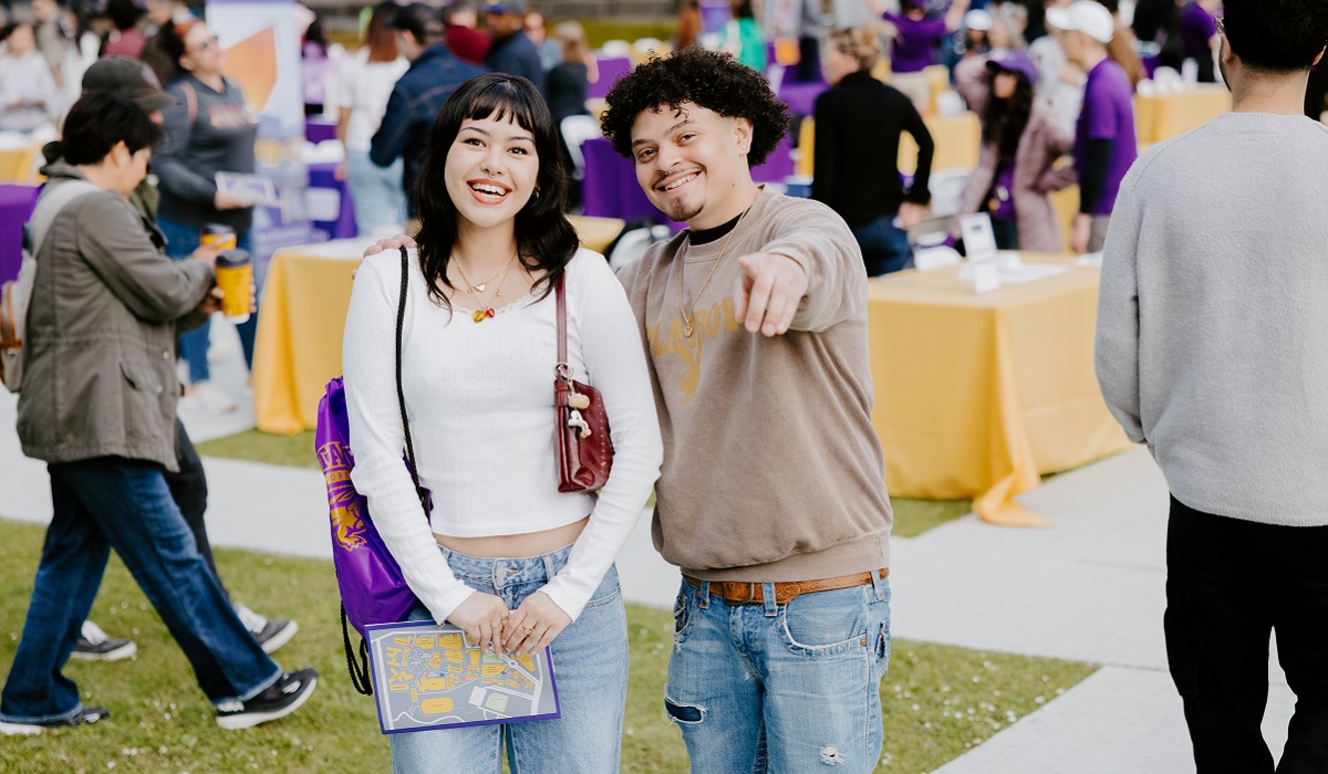 A young woman and young man smile at the camera