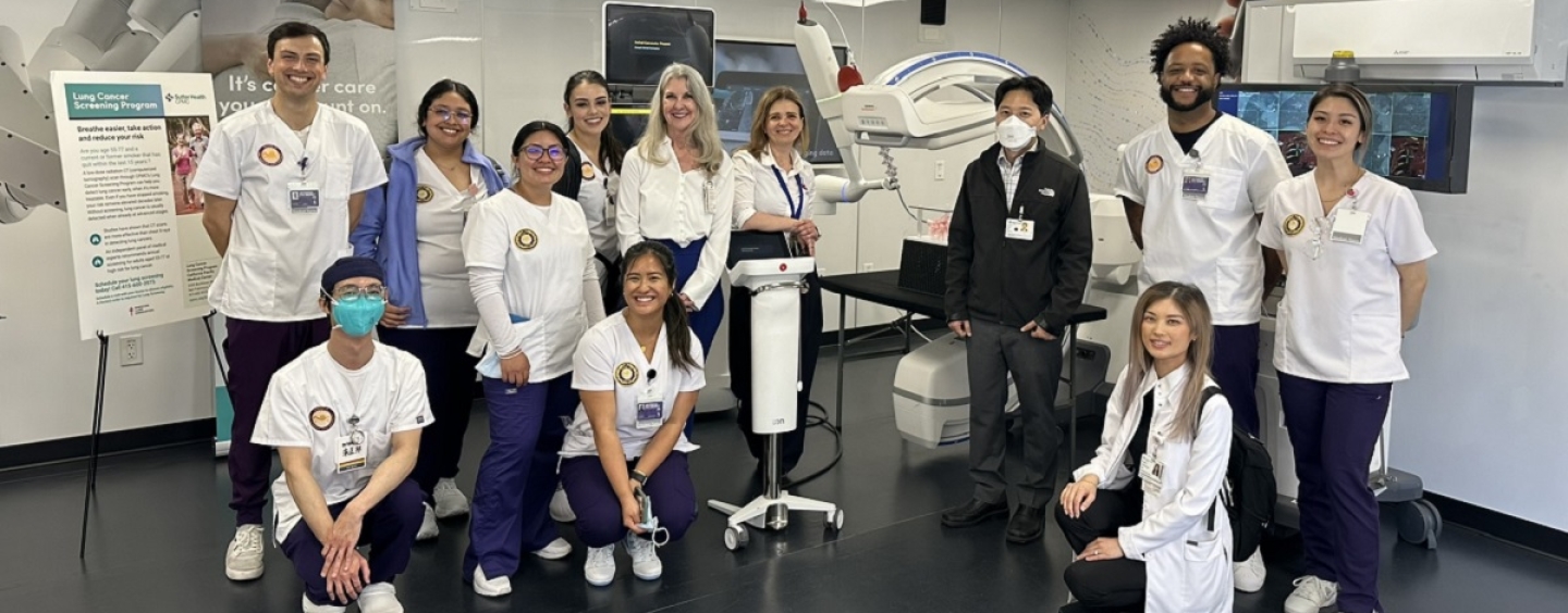 Eight nursing students stand in a lab