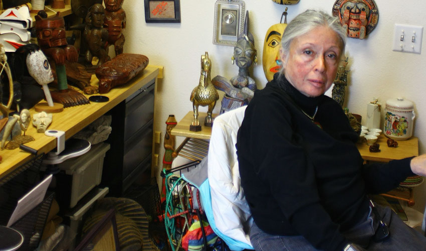 SF State Professor and Chair of Philosophy Anita Silvers in her office, surrounded by colorful mementoes and artwork —gifts given by students and colleagues during the past 50 years.