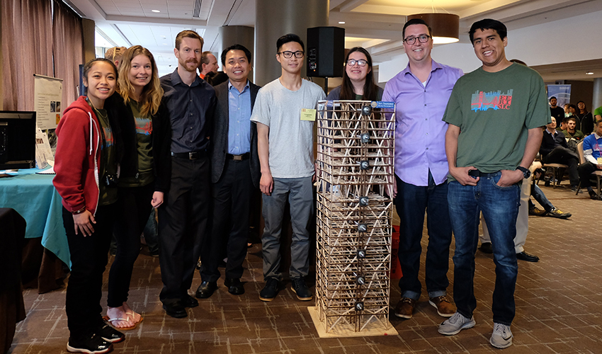 A photo of Kathleen Ocampo, Jamie Brownell, Ryan Schofield, faculty advisor Zhaoshuo Jiang, Lungyuen Lau, Marisa Araujo, project manager Stephen Pereira Schork and Omar Plata with their wood skyscraper model.