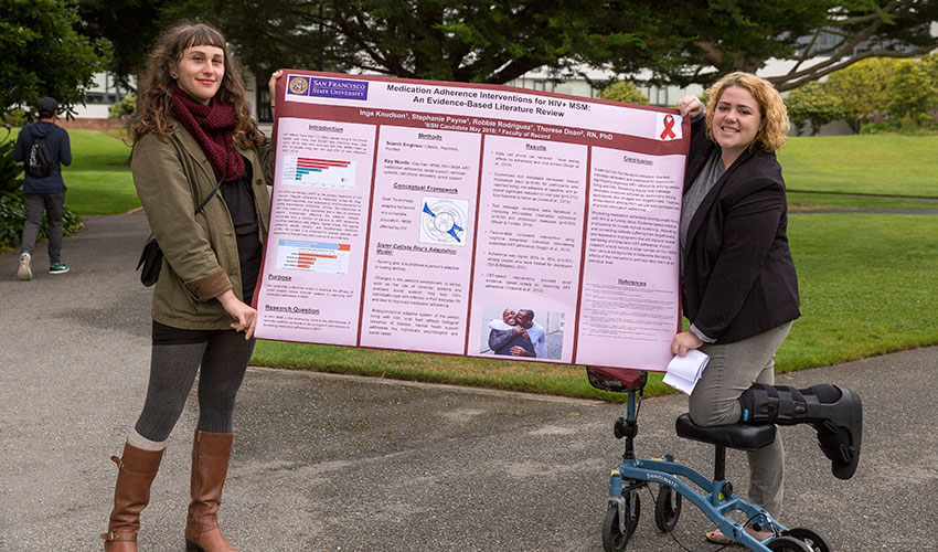 Two SF State students hold a poster that details their analysis of anti-retroviral therapy adherence among men who have HIV.