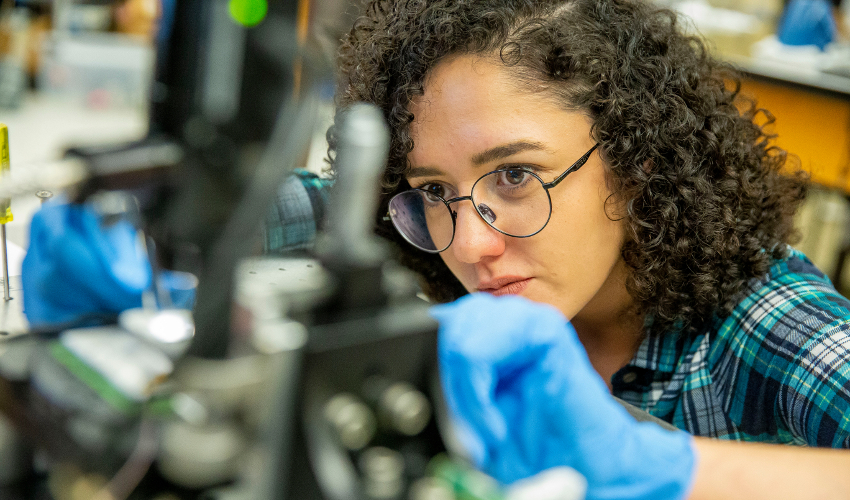 Student in research lab using physics equipment