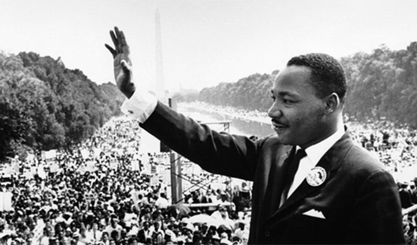 Martin Luther King Jr. waving to a crowd in Washington D.C.'s national mall.