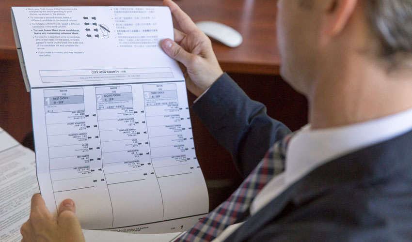 Jason McDaniel, SF State assistant professor of political science, reviews a ranked-choice voting ballot.