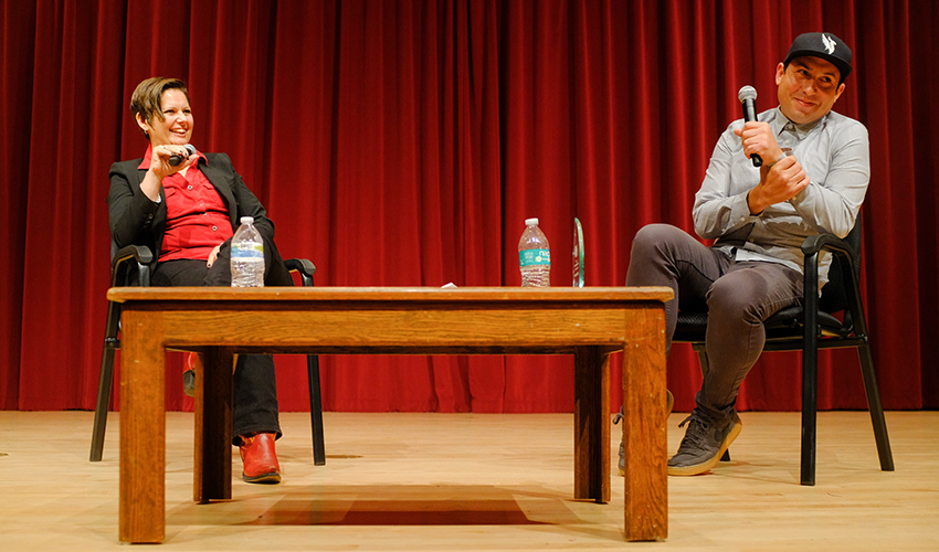 Assistant Professor of Creative Writing Carolina De Robertis sits and chas with author Tommy Orange