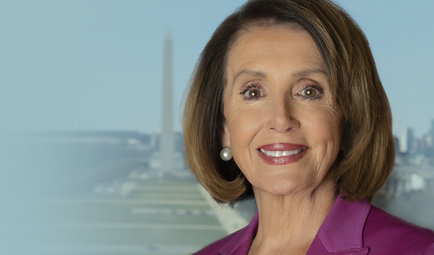Congresswoman and Speaker of the House is pictured wearing a dark pink suit jacket and white shell; the Washington Monument can be seen in the background.
