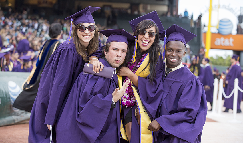 Students smiling at graduation ceremony.