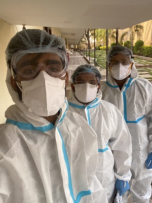 Vandit Malik and two other volunteers in scrubs and masks