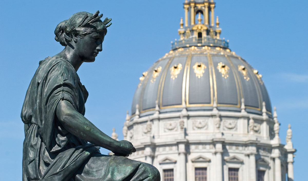 A photo of a statue and the dome of San Francisco City Hall