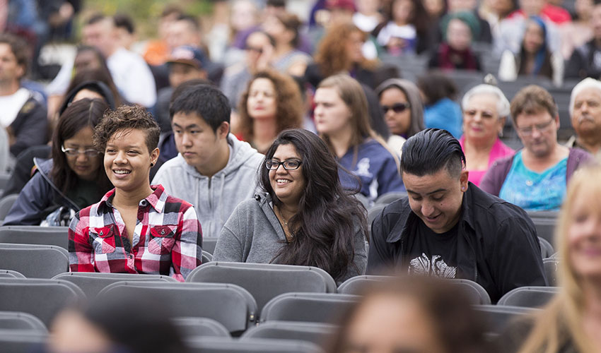 Three SF State students sitting among the audience on the quad during the Welcome Days event in August.