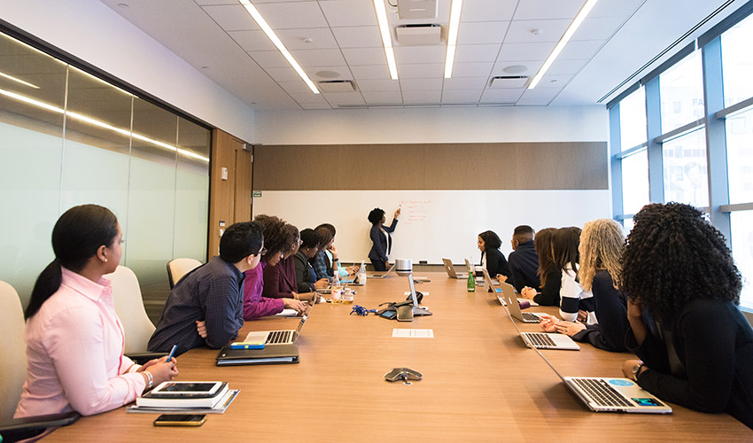 Woman speaking in a boardroom to a group of people