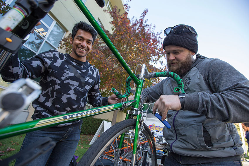 Nolen Brown fixes SF State student Kartik Ravi’s bicycle on campus.