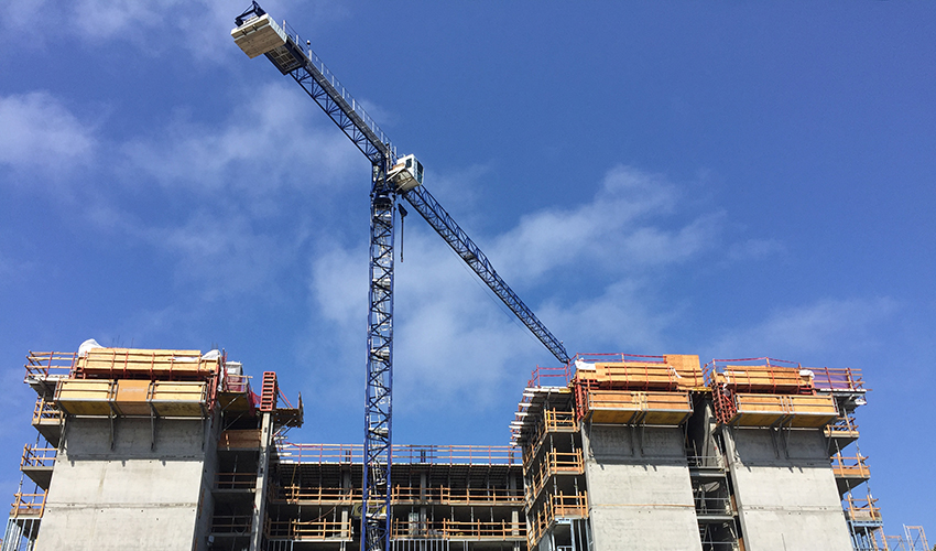 Construction crane next to a building that’s under construction.
