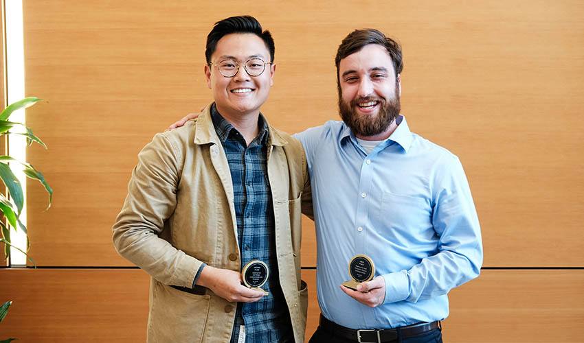 Two students stand side-by-side holding their awards