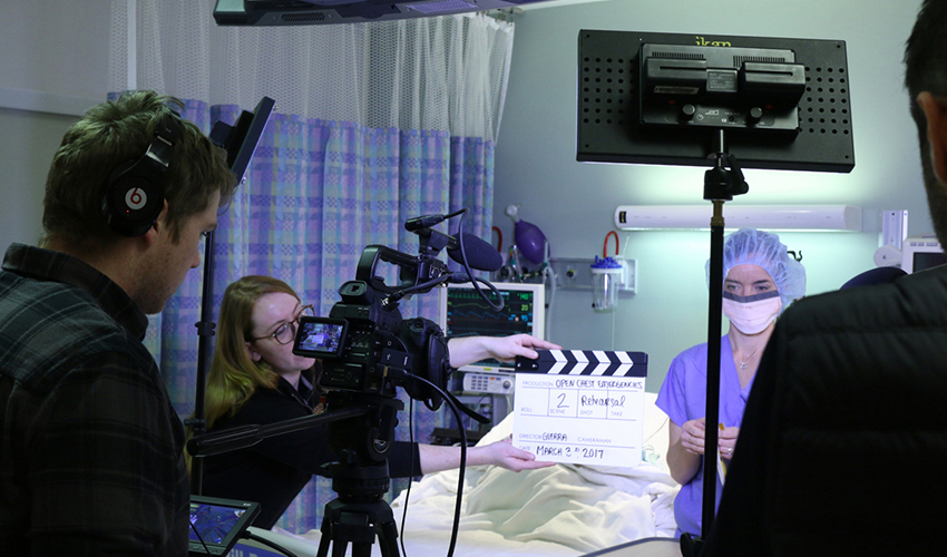 Photo of students and Professor Oscar Guerra shooting video in an operating room