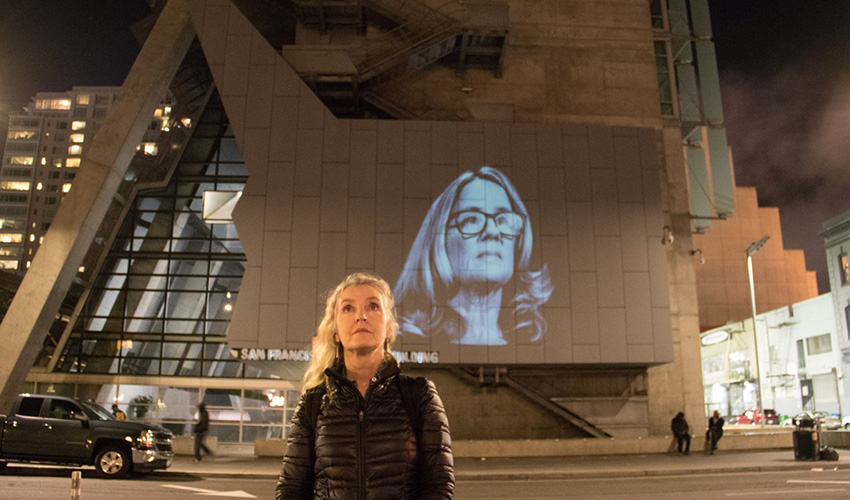 Rebecca Solnit stands in front of a building in downtown San Francisco