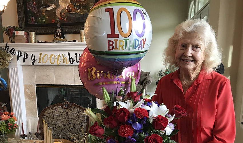 Lucille Wendling poses with balloons and flowers for her 100th birthday celebration