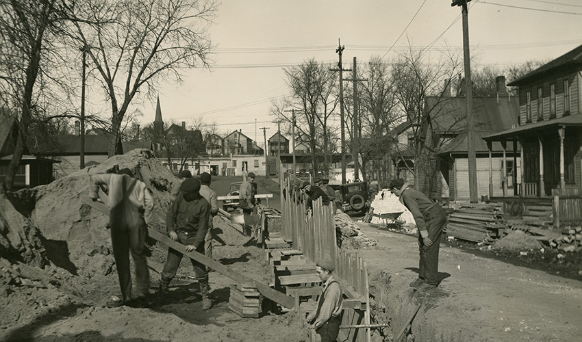 Workers in a trench build a sewer