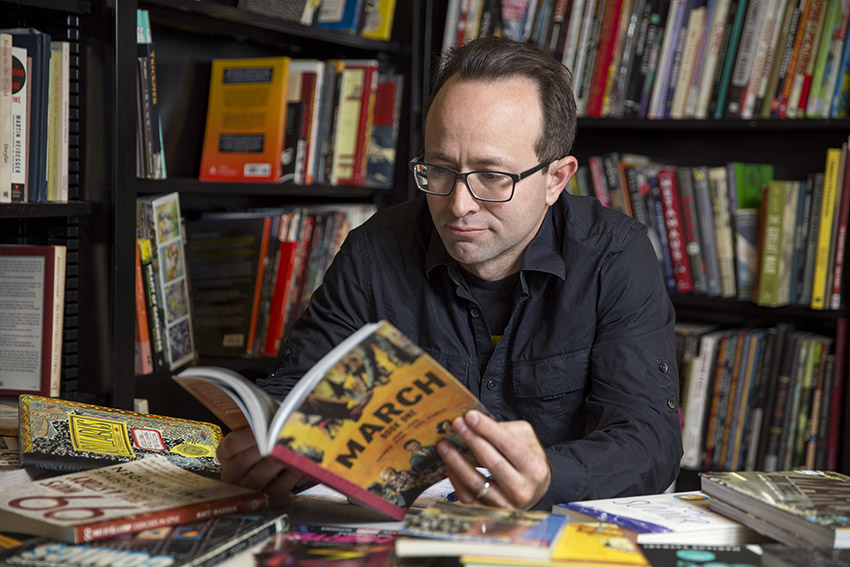 SF State Professor of Humanities and Liberal Studies Nick Sousanis reads a graphic novel in his classroom.