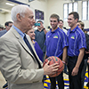 Photo of alum Don Nasser holding a basketball, with student athletes