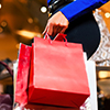 A photo of a woman carrying a red shopping bag