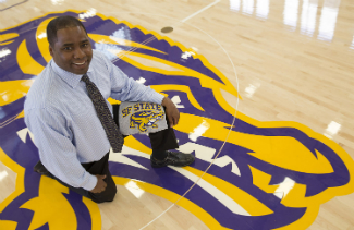 SF State’s director of athletics, Charles Guthrie, in the newly renovated gymnasium with the updated Gator mascot.
