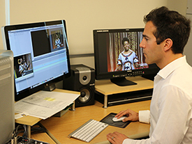 Alex Cherian looks at images of Maya Angelou on his computer screens.