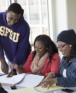 Three SF State students discuss an assignment at a table in the SF State Library.