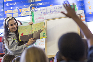 An SF State student reads a story at an elementary school
