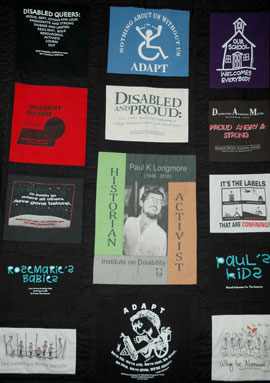 Photo of a quilt with a black background and 20 images taken from Paul Longmore's collection if disability related T-shirts.