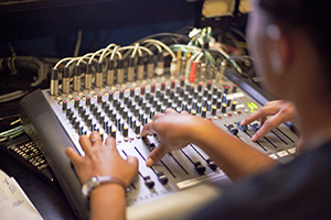 A photo of a student working a sound board.