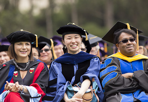 Three members of the audience during SF State's graduate Commencement ceremony