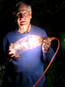 Photo of Professor of Biology John Hafernik holding a zombee light trap.