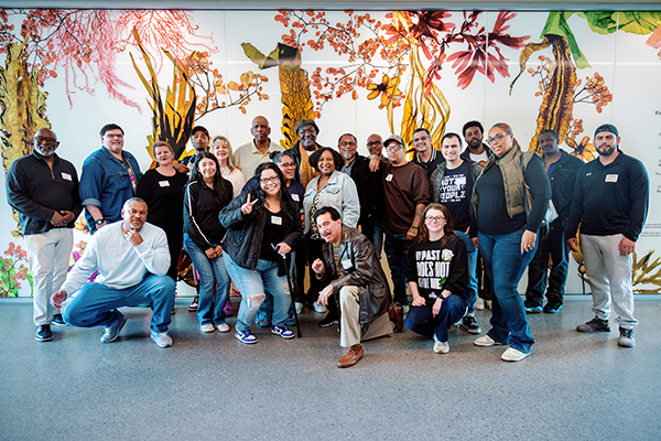 Project Rebound students pose for a group photo with Delroy Lindo in the hallway of the SFSU Science and Engineering Innovation Center