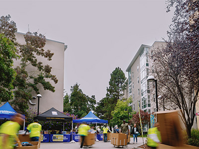 People wearing neon green shirts pushing moving boxes