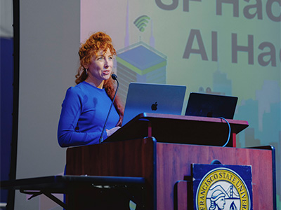 Kelly Cure speaking at the podium