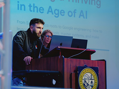 Taso Grigoriou talking at the podium