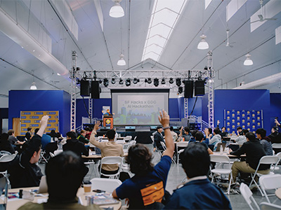 Students at the hackathon raising their hands