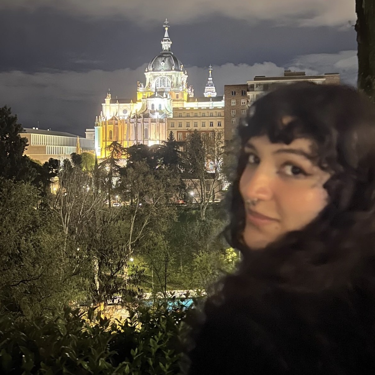 A young woman poses in front of an old building in Spain
