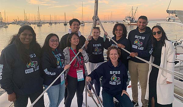 Eight SFSU students and Professor Pleuni Pennings wearing CODE lab sweatshirts