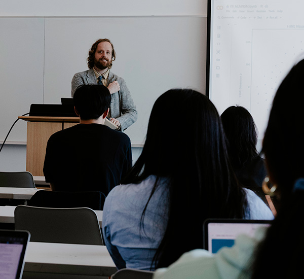 Professor at podium talking about Powerpoint slides