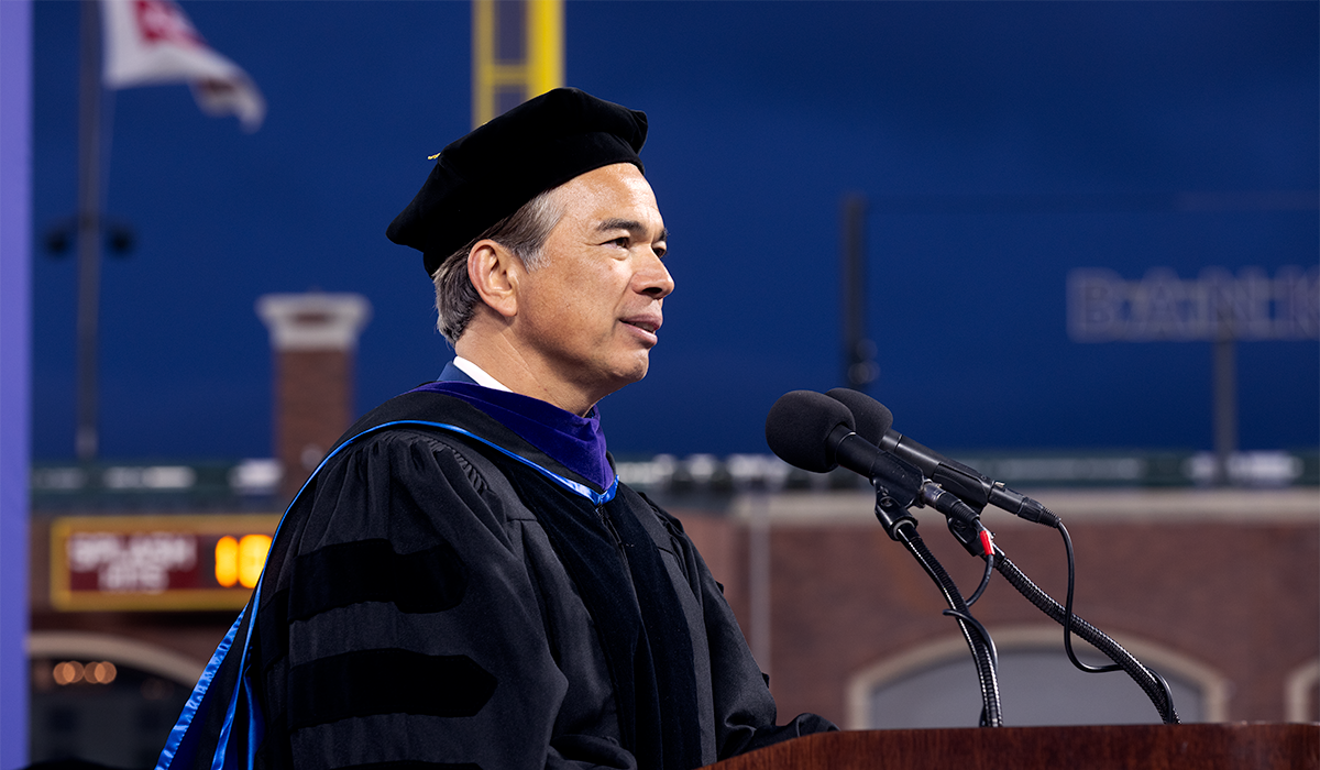 Rob Bonta speaks behind a podium on the platform at SFSU Commencement at Oracle Park