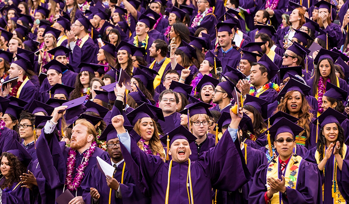 Students in purple caps and gowns celebrate at SFSU Commencement