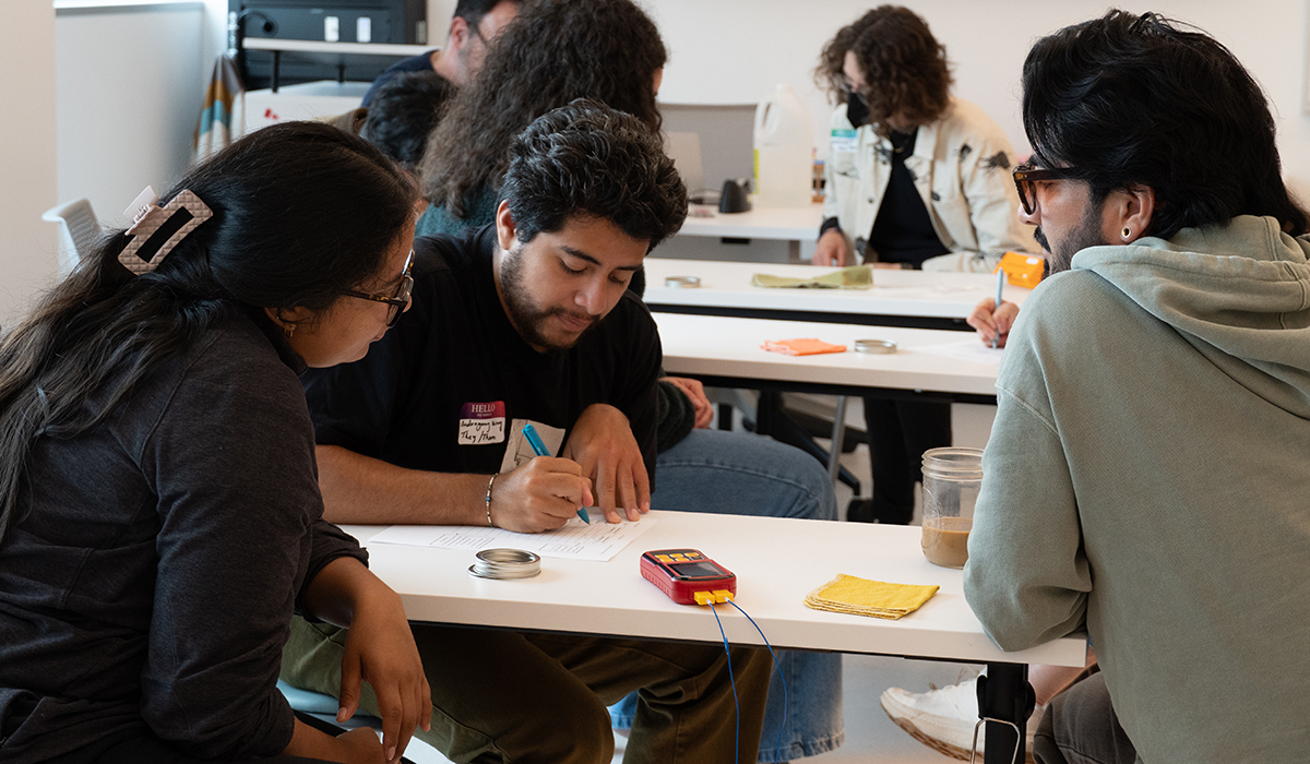 Three students at a table working on an activity together in the classroom.