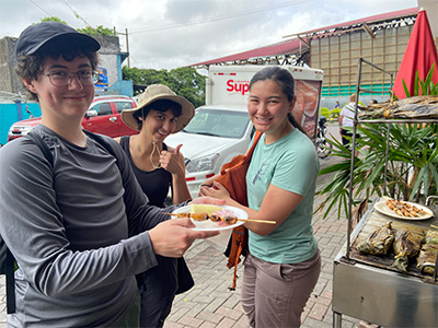 Three students eating street food (insects)
