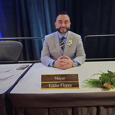 Eddie Flores sits at a table in front of his name tag