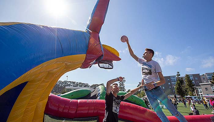 Student jumping towards the net on an inflatable basketball court 