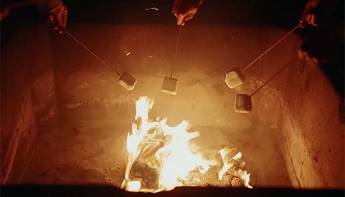 Hands roasting marshmallows for smores