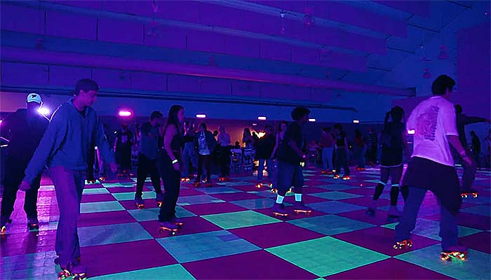 Students rollerskating in a glow-in-the-dark room