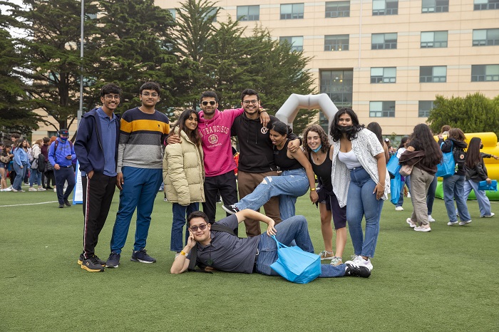 A group of students pose together on the West Campus Green